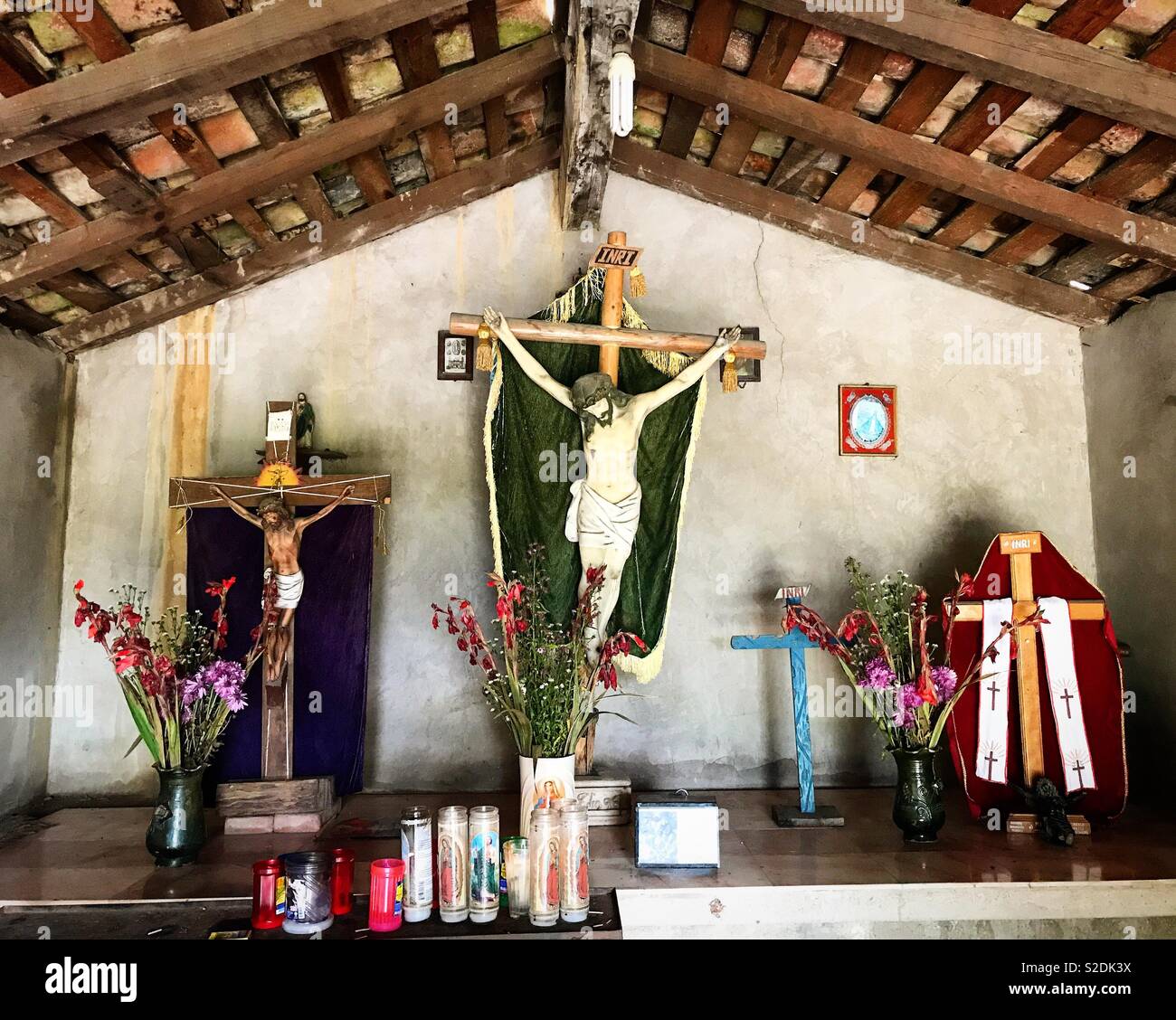 Cruces e imágenes de Jesucristo crucificado decorar un altar en una capilla  en la Sierra Norte de Oaxaca, México Fotografía de stock - Alamy
