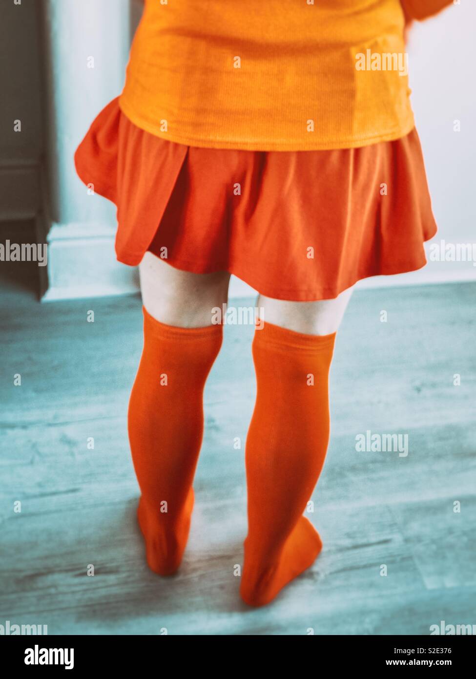 Cosplayer femenino como Velma. Vestidos de naranja Foto de stock