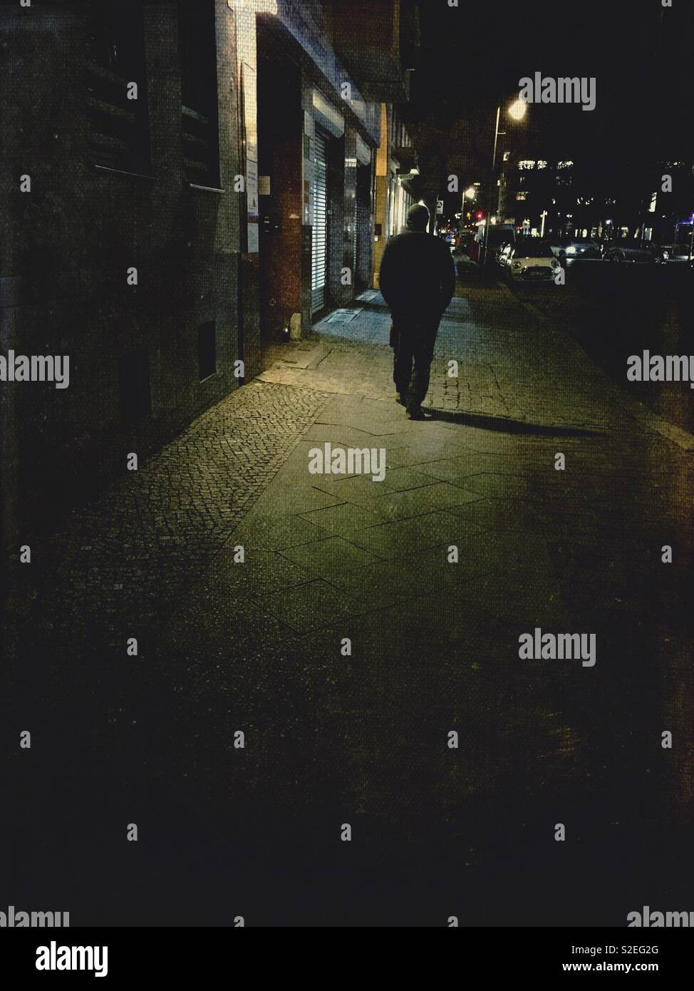 Hombre caminando en la calle por la noche Fotografía de stock - Alamy