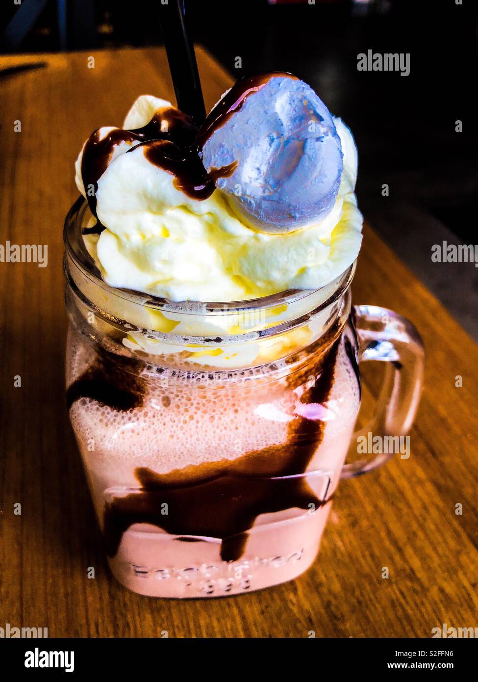 Batido de chocolate con helado de vainilla y malvaviscos con el aderezo de  jarabe de chocolate Fotografía de stock - Alamy