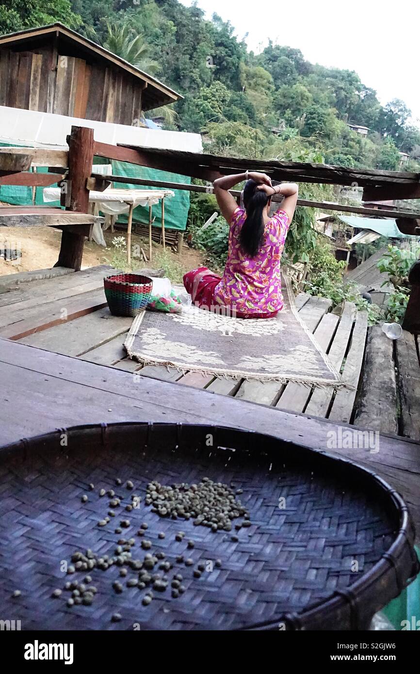 Lahu hilltribe: la vida de la aldea. Mujer cepillarse el cabello. Vista trasera Foto de stock