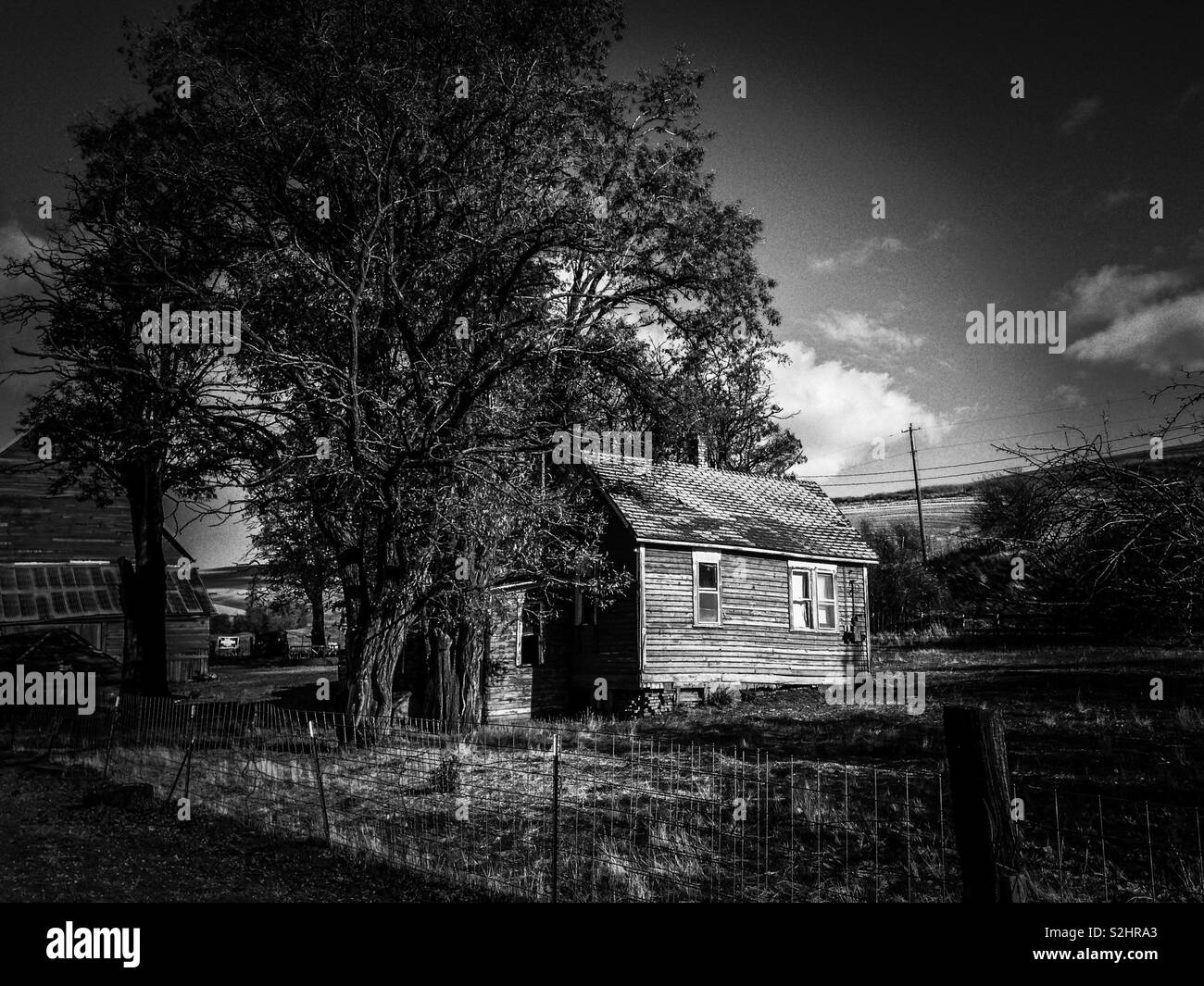 Fotografía en blanco y negro de Washington oriental granja contra la ladera en noviembre Foto de stock