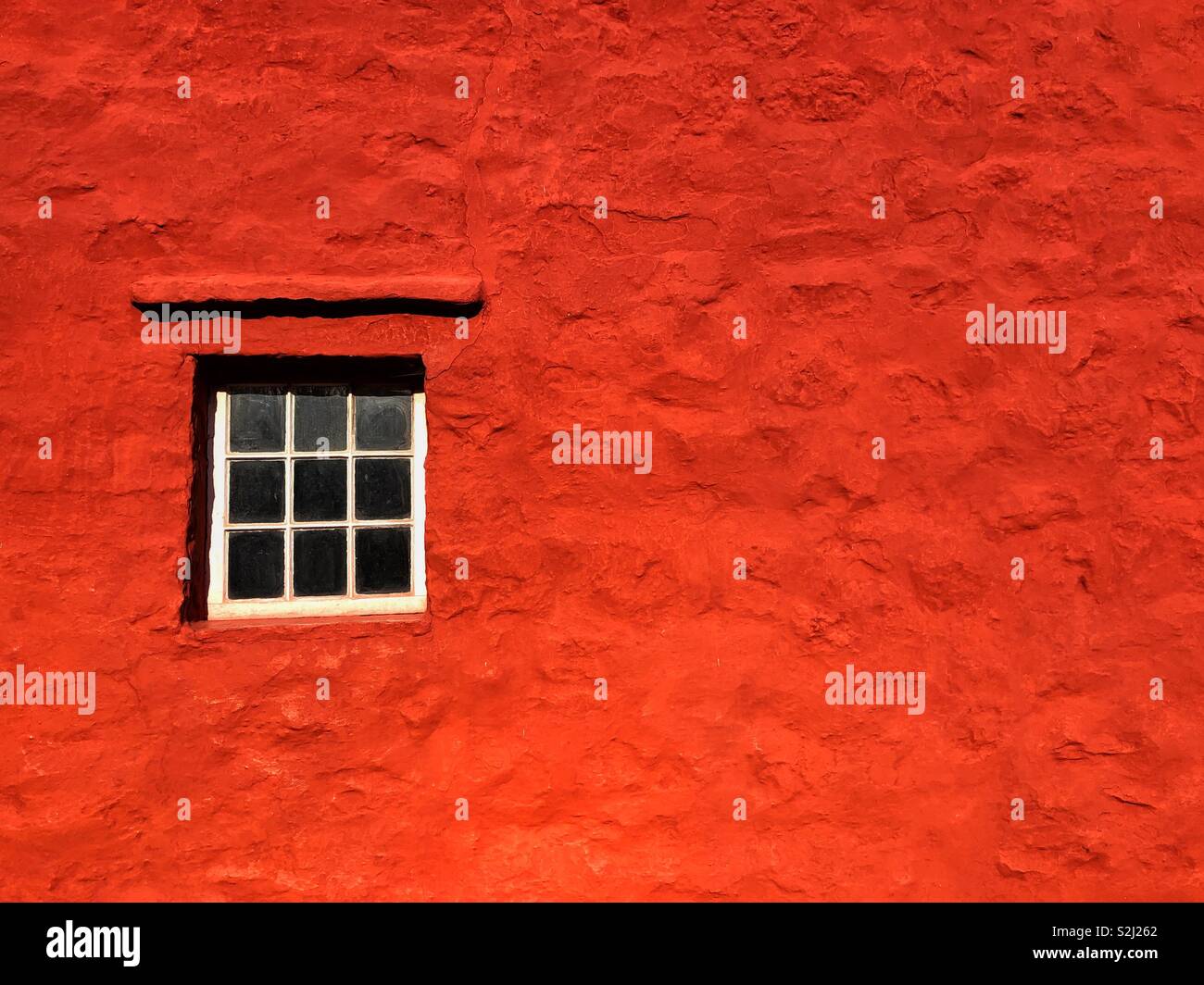 Una ventana en una pared de color rojo en una antigua casa de campo en St Fagans Museo de la vida, al sur de Gales. Foto de stock