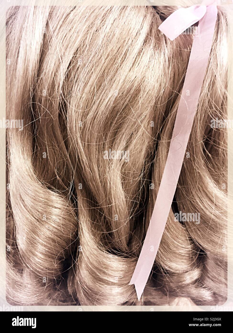 Cerca de una peluca rubia largo con cinta lavanda Fotografía stock - Alamy