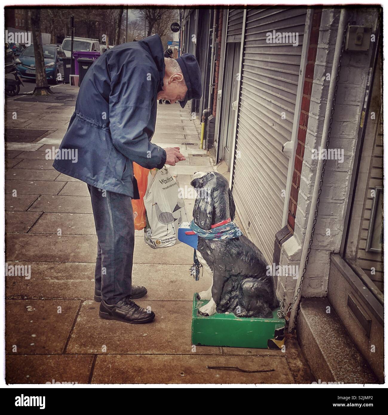 Viejo hombre encontrar cambio para la RSPCA Caja de recogida. Foto de stock