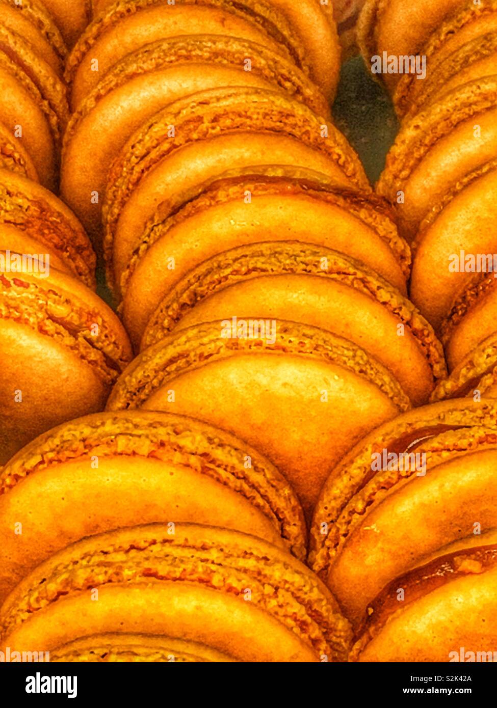 Delicias recién horneadas naranja macaron cookies y llenado de coincidencia como un delicioso postre delicioso. Foto de stock