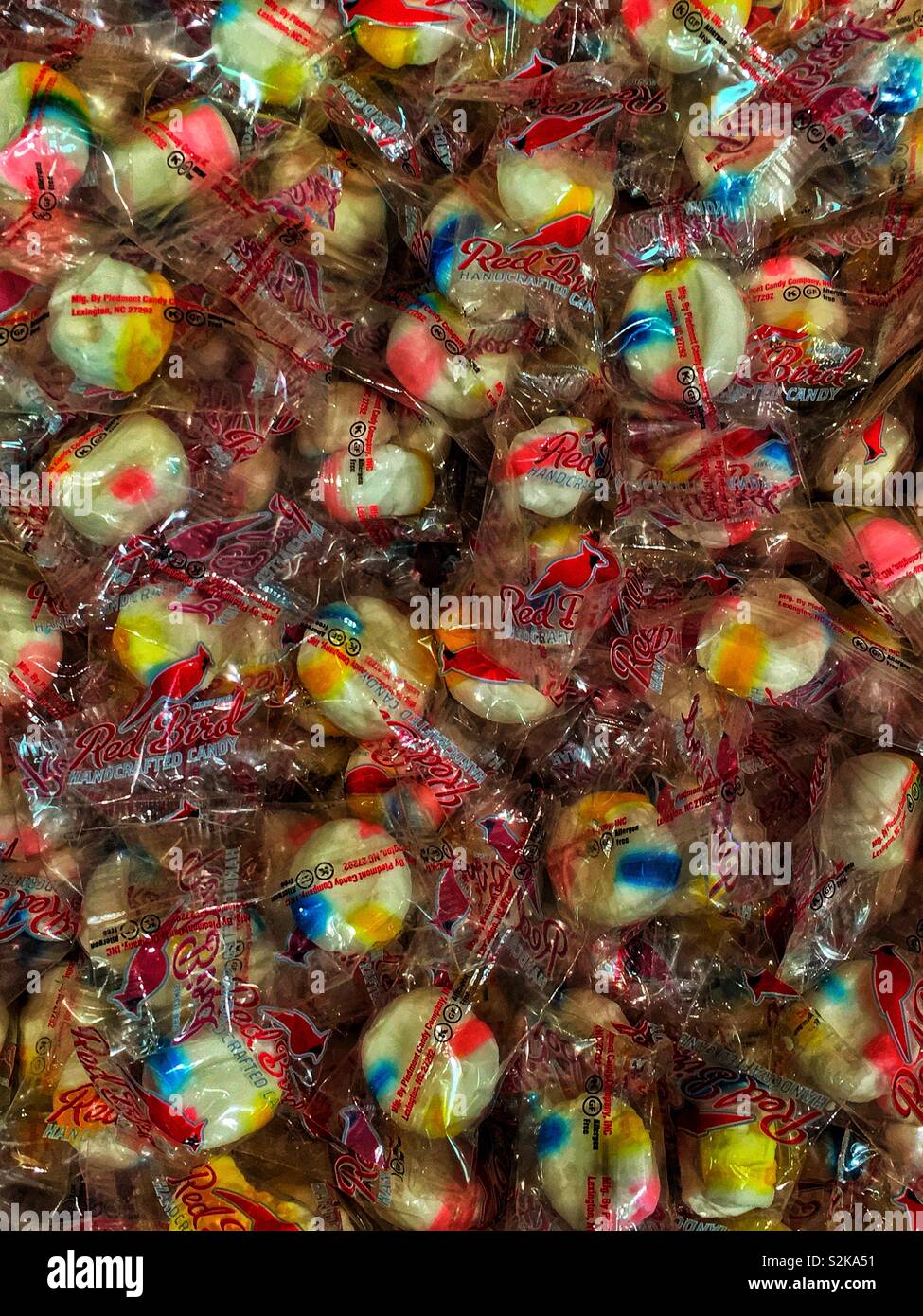 Fotograma completo de Pájaro Rojo solo envuelto caramelos se amontona en una bandeja para la venta. Foto de stock