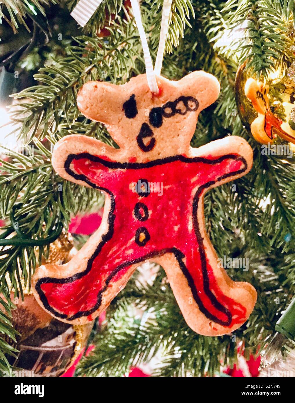 Navidad caseras Teddy bear en pijama roja hecha de masa de galleta seca con color y marcador Sharpie dibujo desde niño pequeño árbol de Navidad Foto de stock