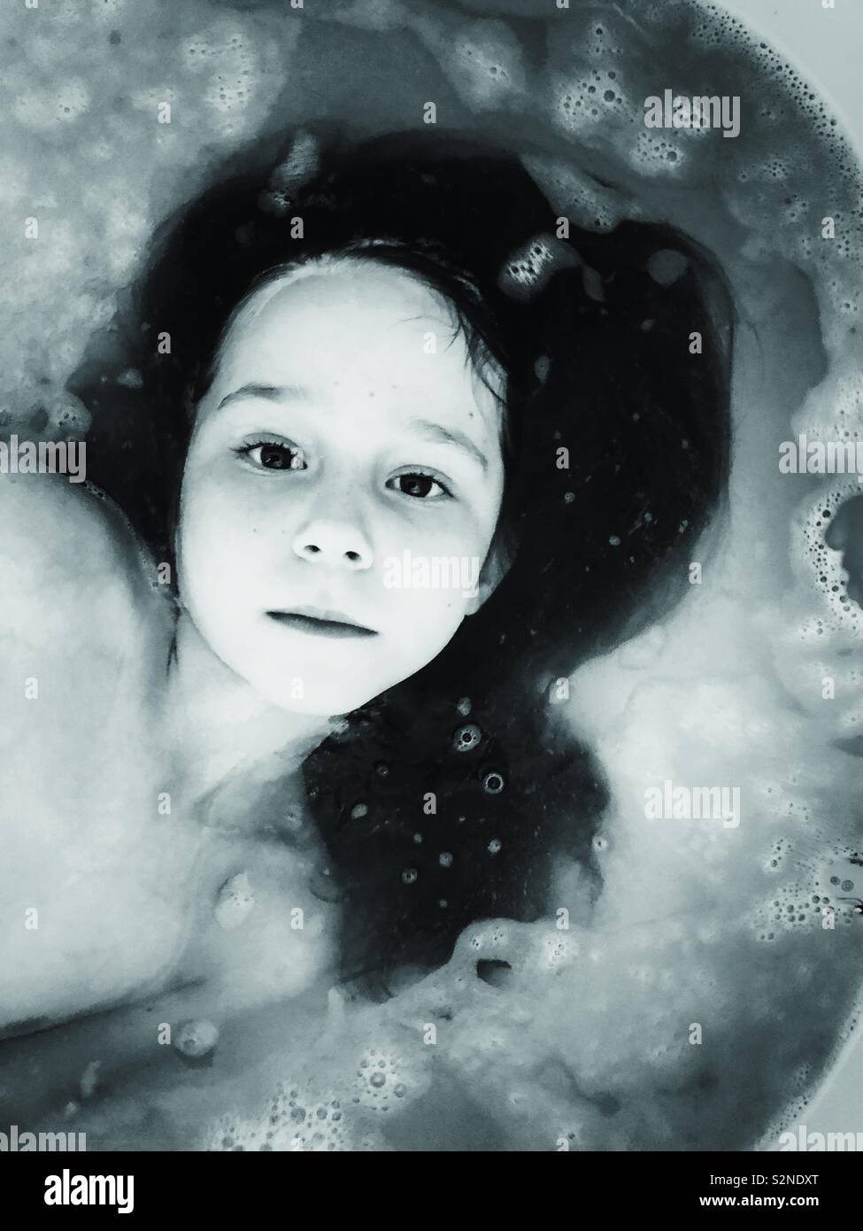 Child girl submerged in bubble bath fotografías e imágenes de alta