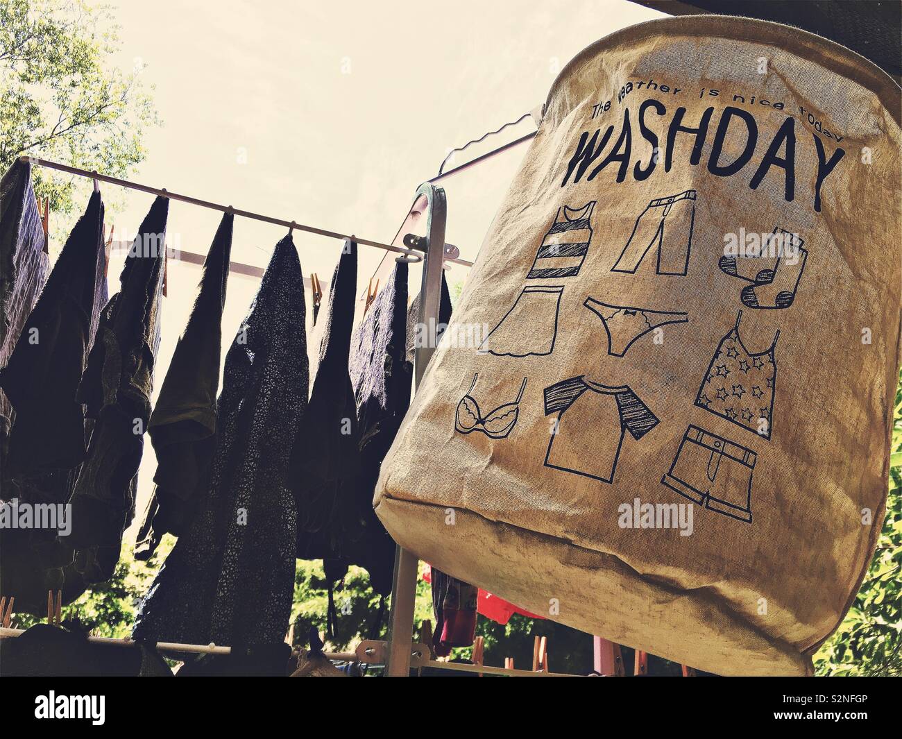 Ropa colgando fuera a secar en una percha de metal. Un día de lavado de ropa material bolsa en primer plano. Foto de stock