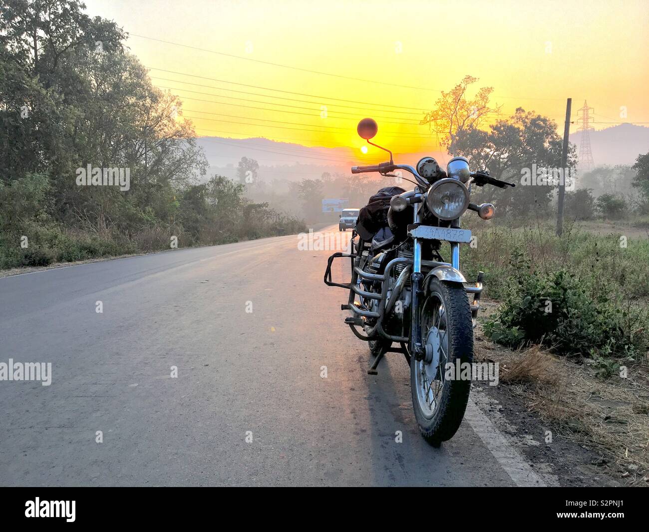 Foto de una motocicleta empaquetada en una carretera al amanecer. Foto de stock