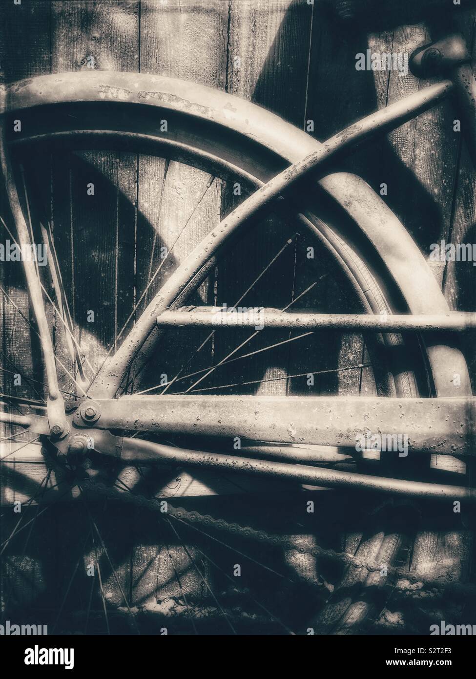 Neumático trasero de una bicicleta vintage contra una valla de madera Foto de stock