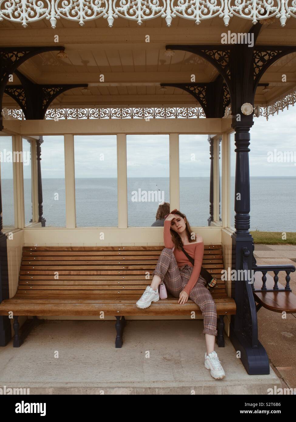 Chica sentado en la playa con vistas al mar vivienda Foto de stock