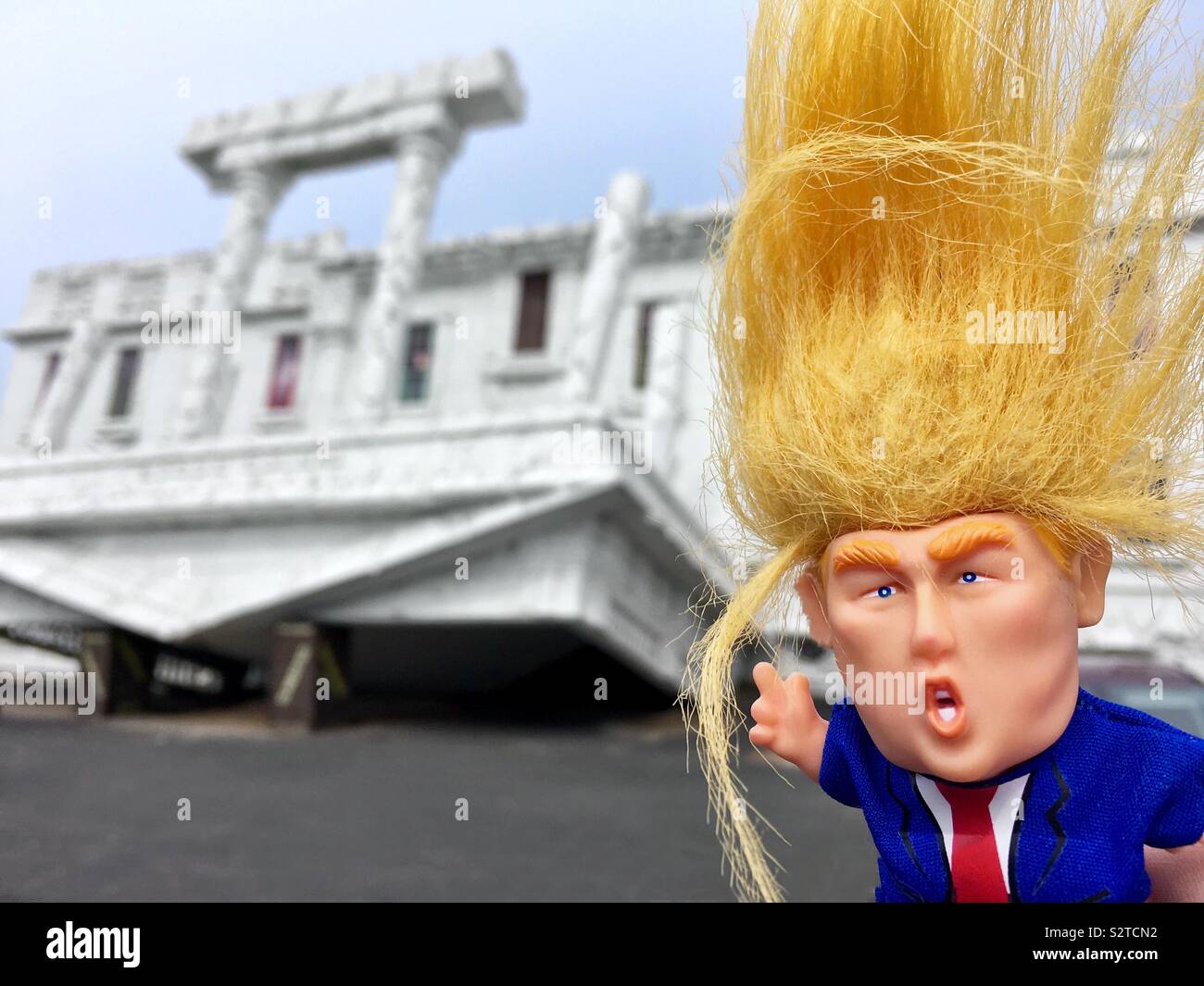 Donald Trump troll con pelo naranja salvaje está en frente de la Casa Blanca al revés Foto de stock
