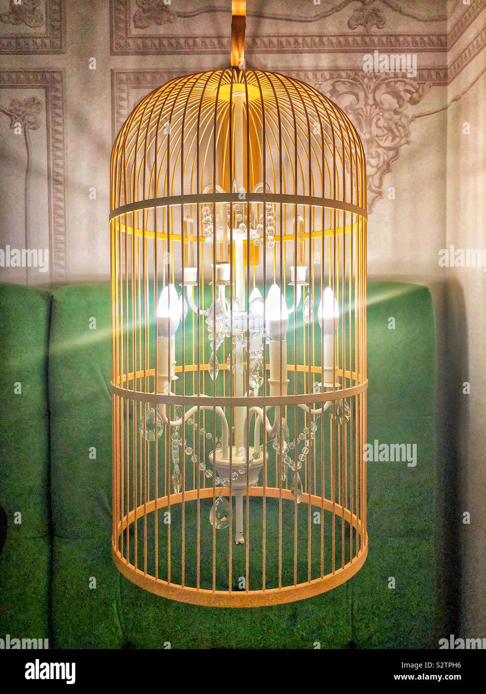Un único yellow bird cage con una araña de luces luz dentro de ella Foto de stock