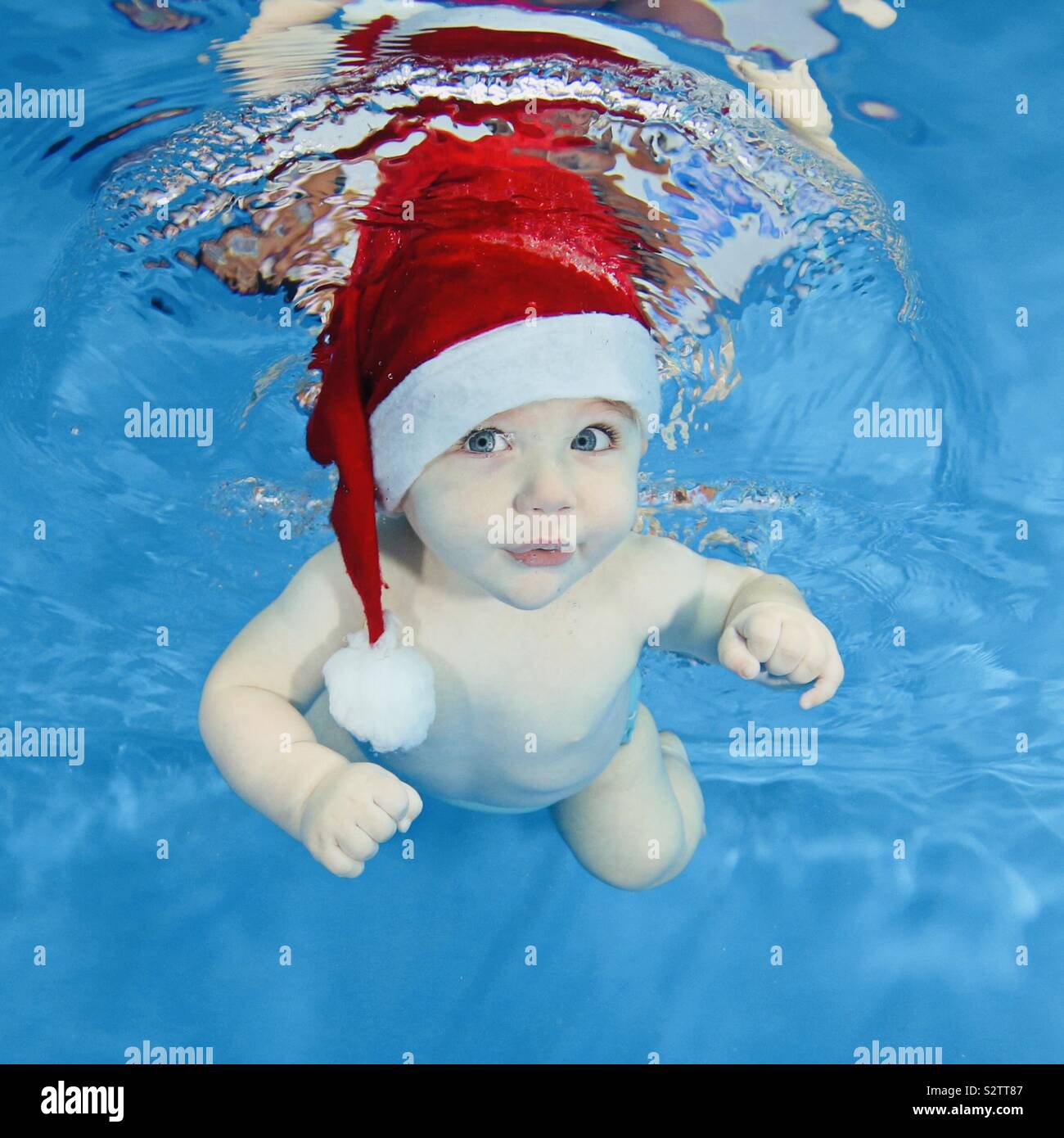 Bebé llevar gorro de Papá Noel en la piscina Fotografía de stock