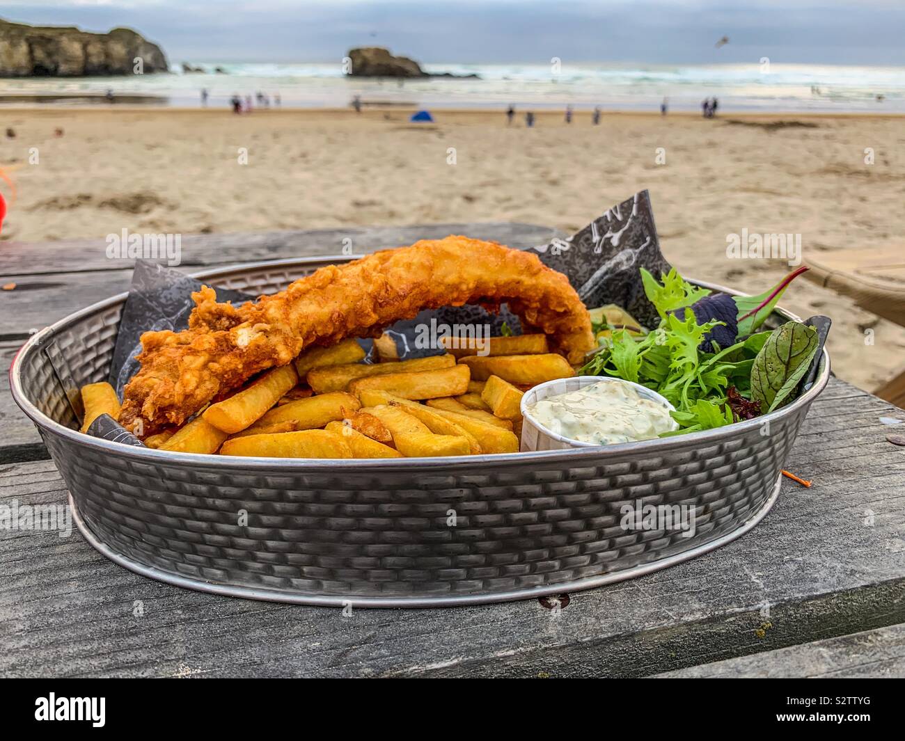 Pescado y patatas fritas en un plato servido en la playa Fotografía de  stock - Alamy