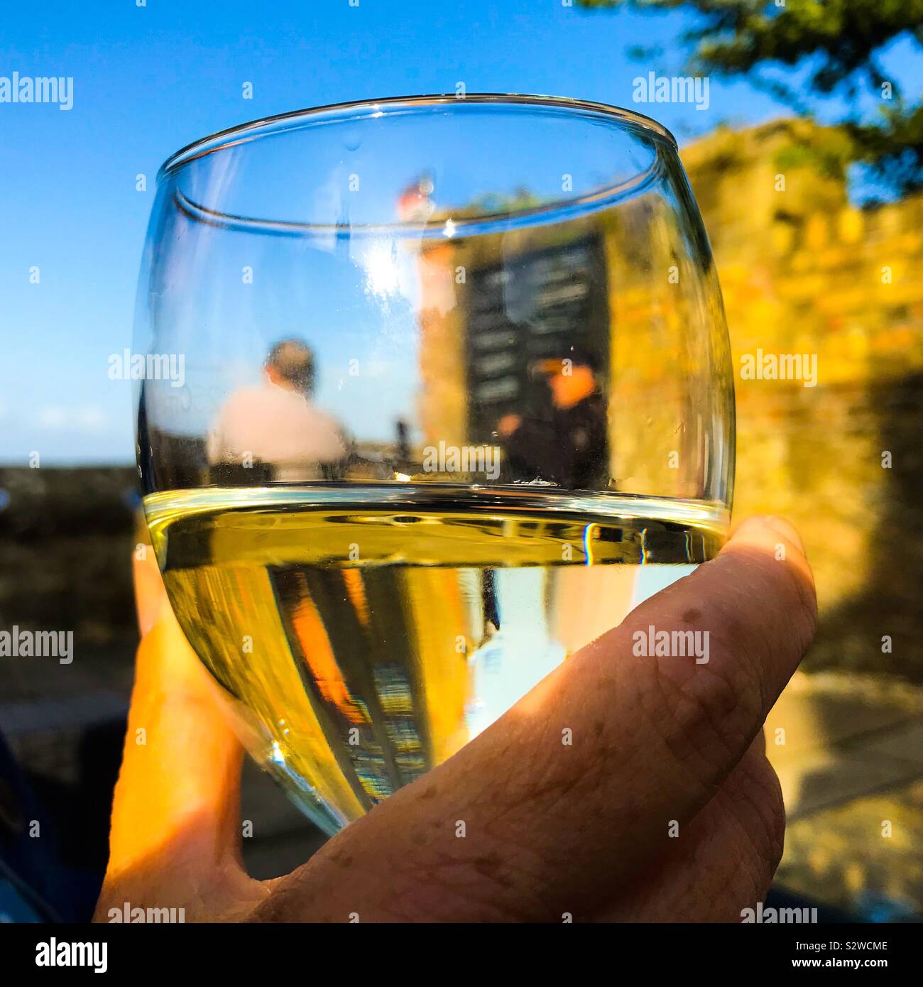 Copa de vino en mano en un pub costera fuera de zona de asientos Foto de stock