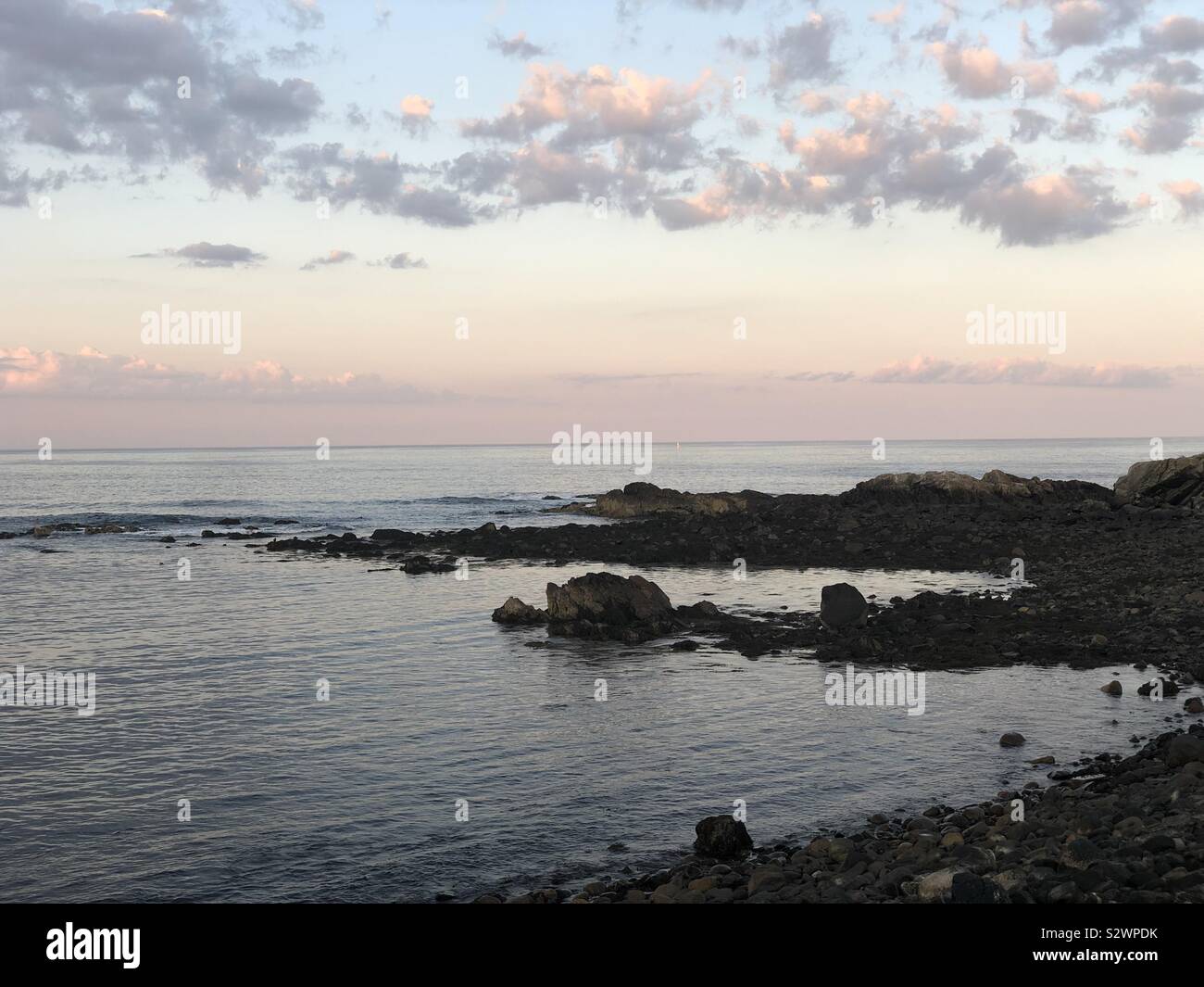 La costa de Maine, el océano, las rocas, las nubes del atardecer Foto de stock