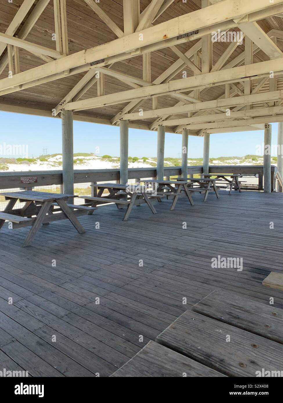 Pabellón al aire libre en la playa, área de picnic con mesas y vista de dunas de arena blanca Foto de stock