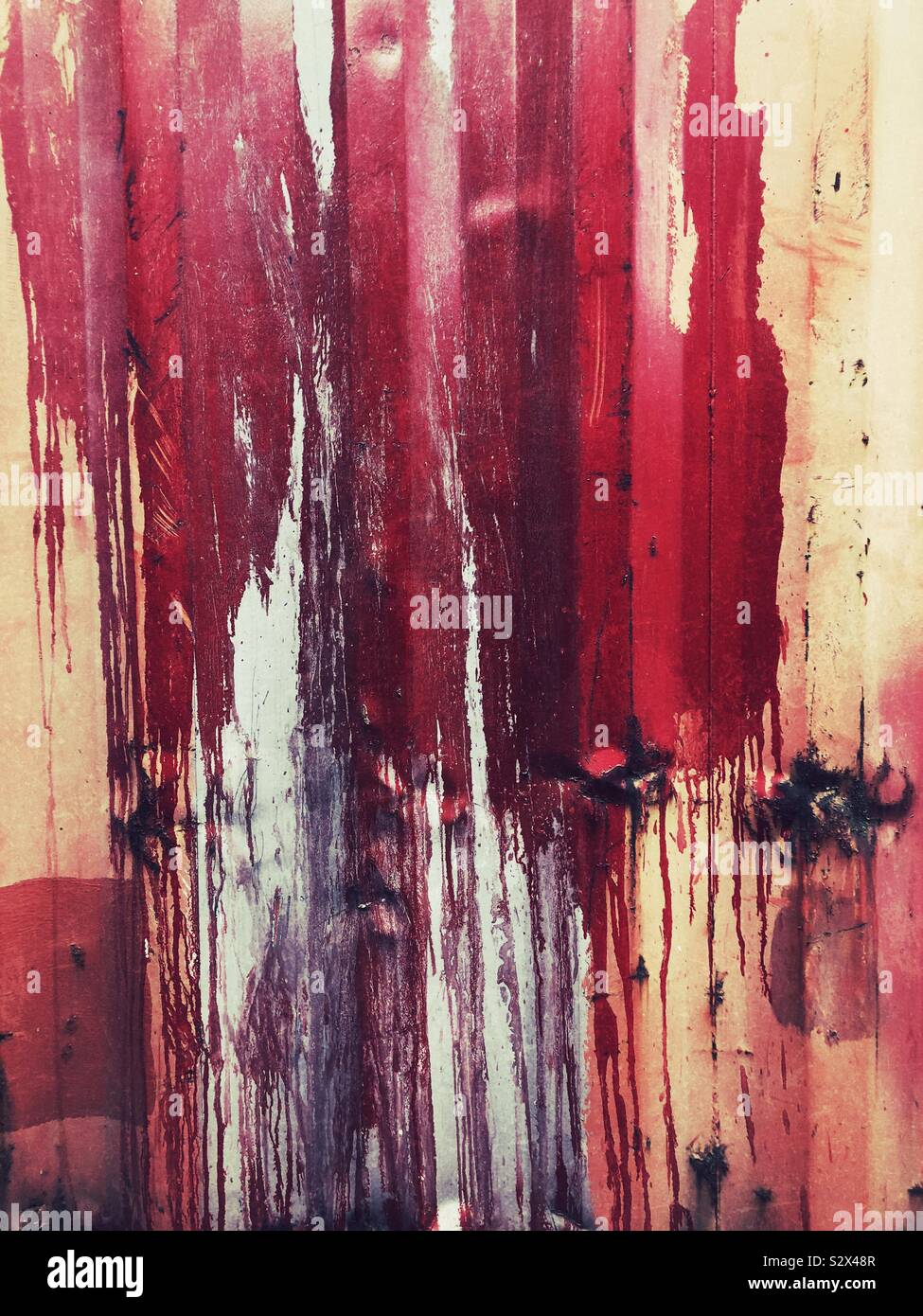 Pintura roja de derrames y goteos en la pared Foto de stock