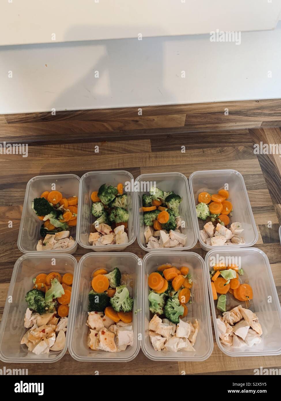 Variedad de comida para llevar en recipientes para microondas con verduras  en la mesa de la cocina, vista superior