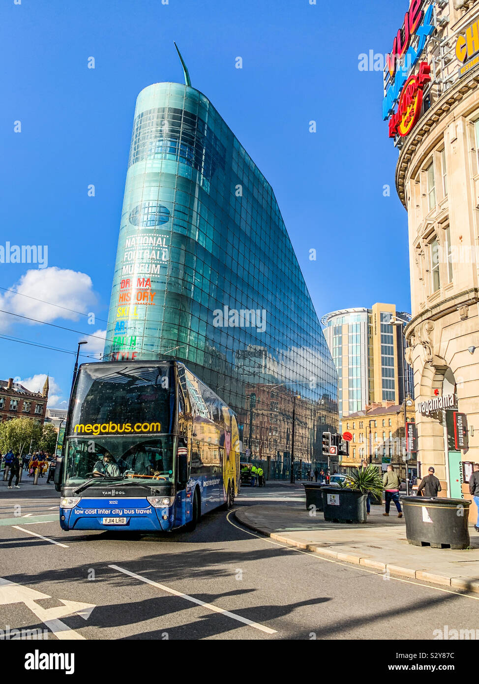 Megabús pasando por el museo nacional del fútbol en Manchester. Foto de stock