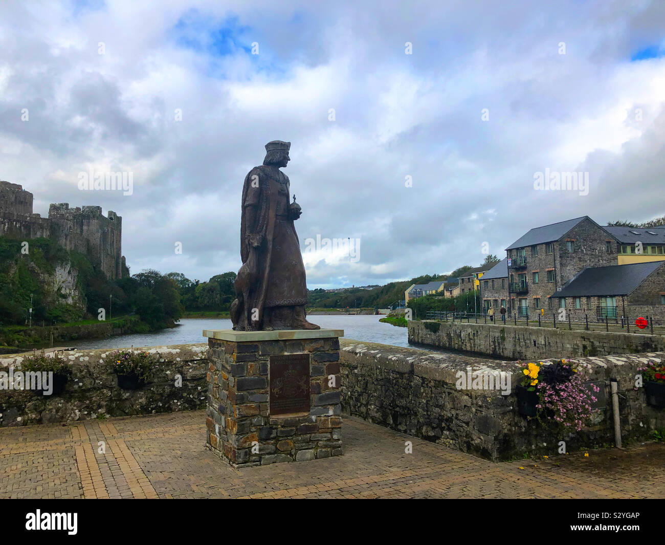 Estatua del rey Enrique VII por el estanque, y el castillo de Pembroke Castle a la izquierda en Pembroke, Pembrokeshire (Gales, Reino Unido. Foto de stock