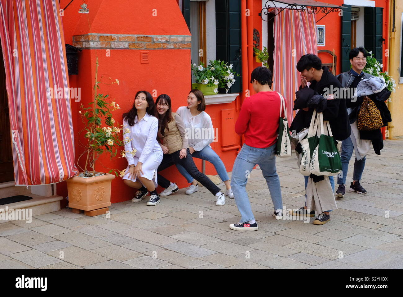 Turismo de Asia las niñas posar para las fotos por una pared de colores brillantes Foto de stock