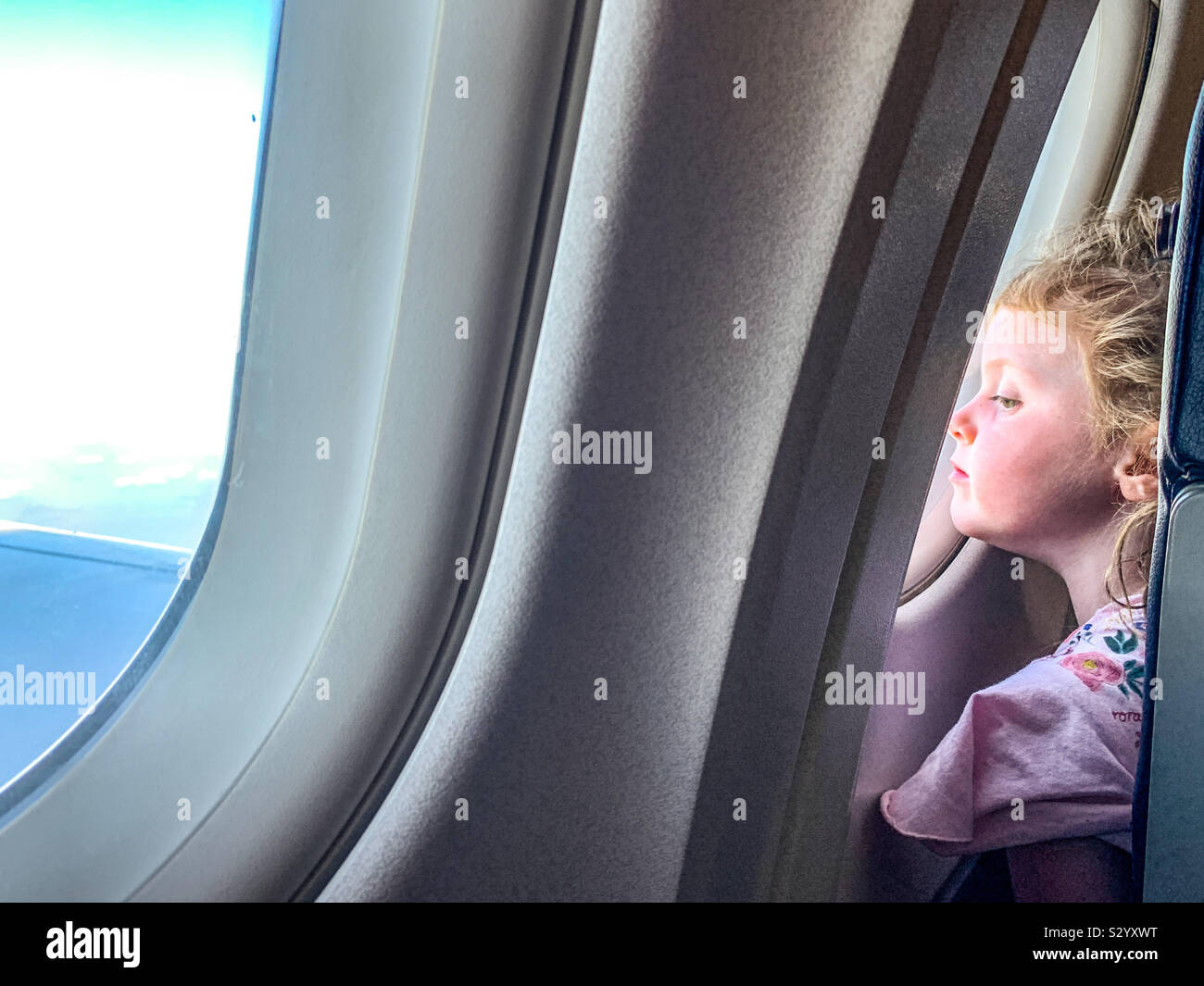 Joven en busca de un avión mientras volaba de ventana Foto de stock
