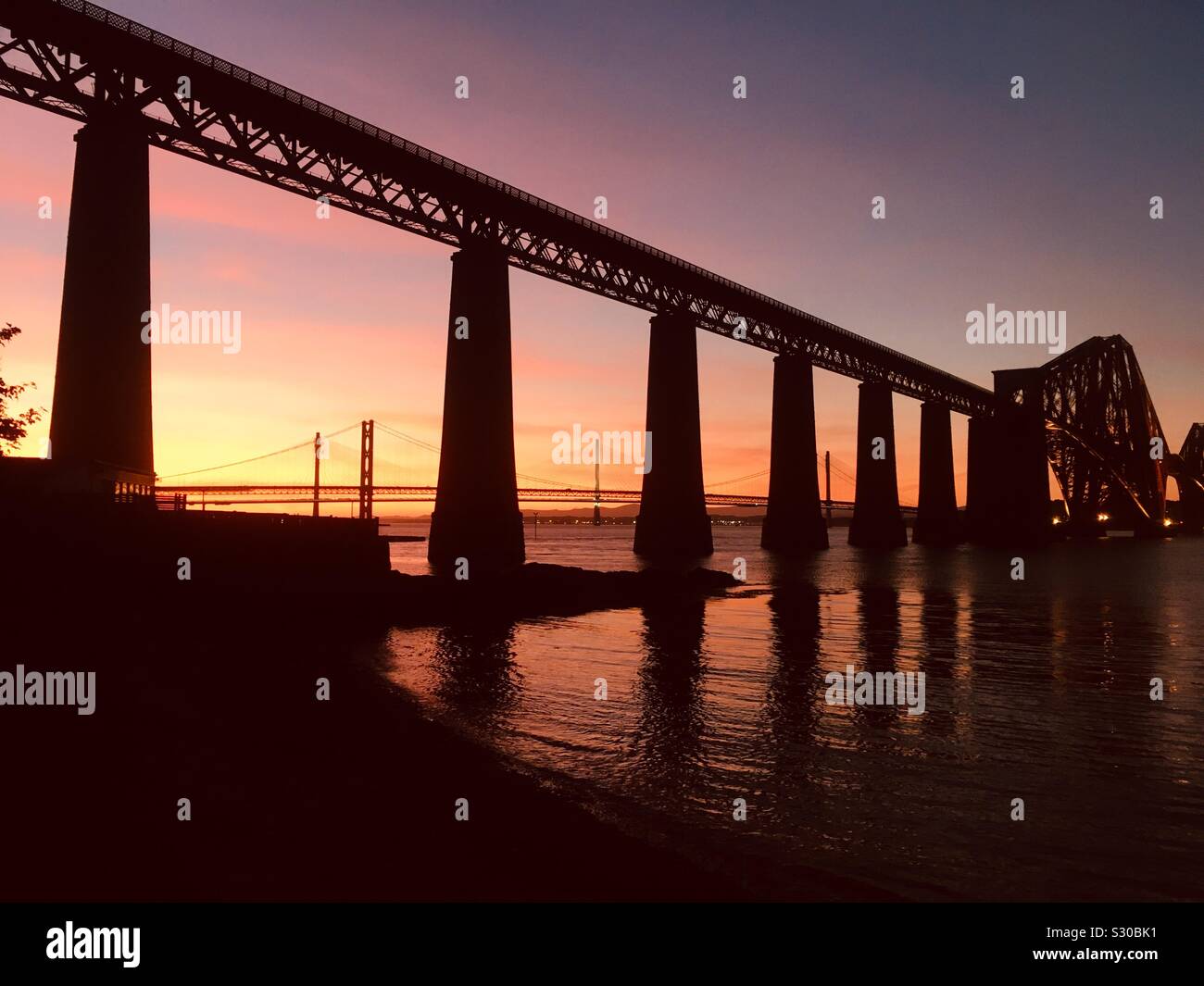 Septiembre atardecer en el Forth Rail y puentes de carretera, South Queensferry, Escocia Foto de stock