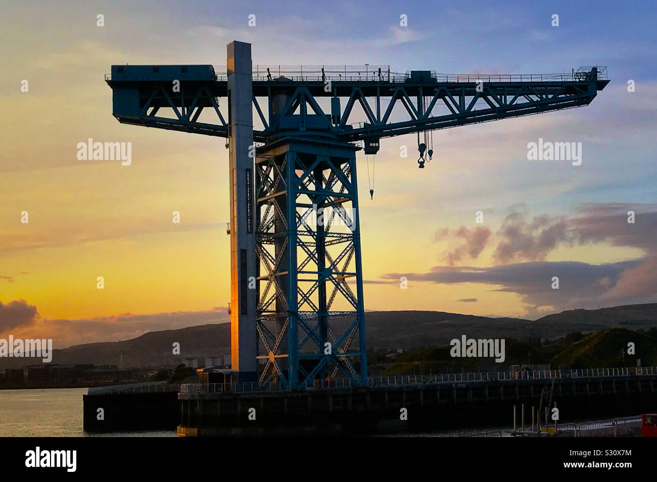 Puesta de sol detrás de Titan Crane en Queens Quay Clydebank, en el río
