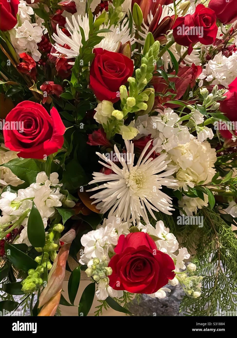 Ramo de flores con rosas rojas, flores blancas y relleno verde Fotografía  de stock - Alamy