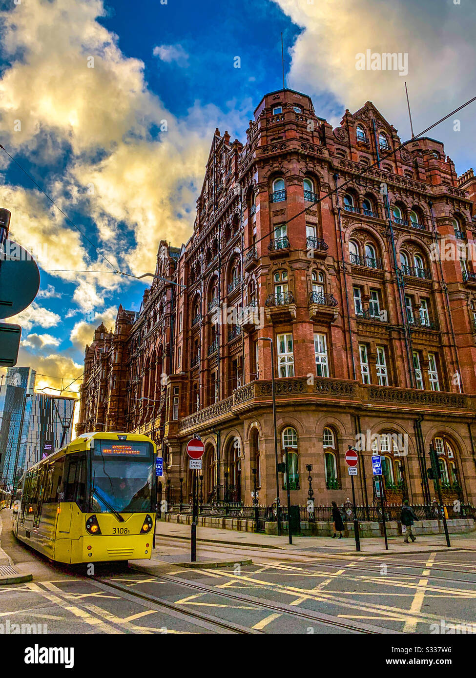 El tranvía Metrolink pasa por el hotel midland en Manchester Foto de stock