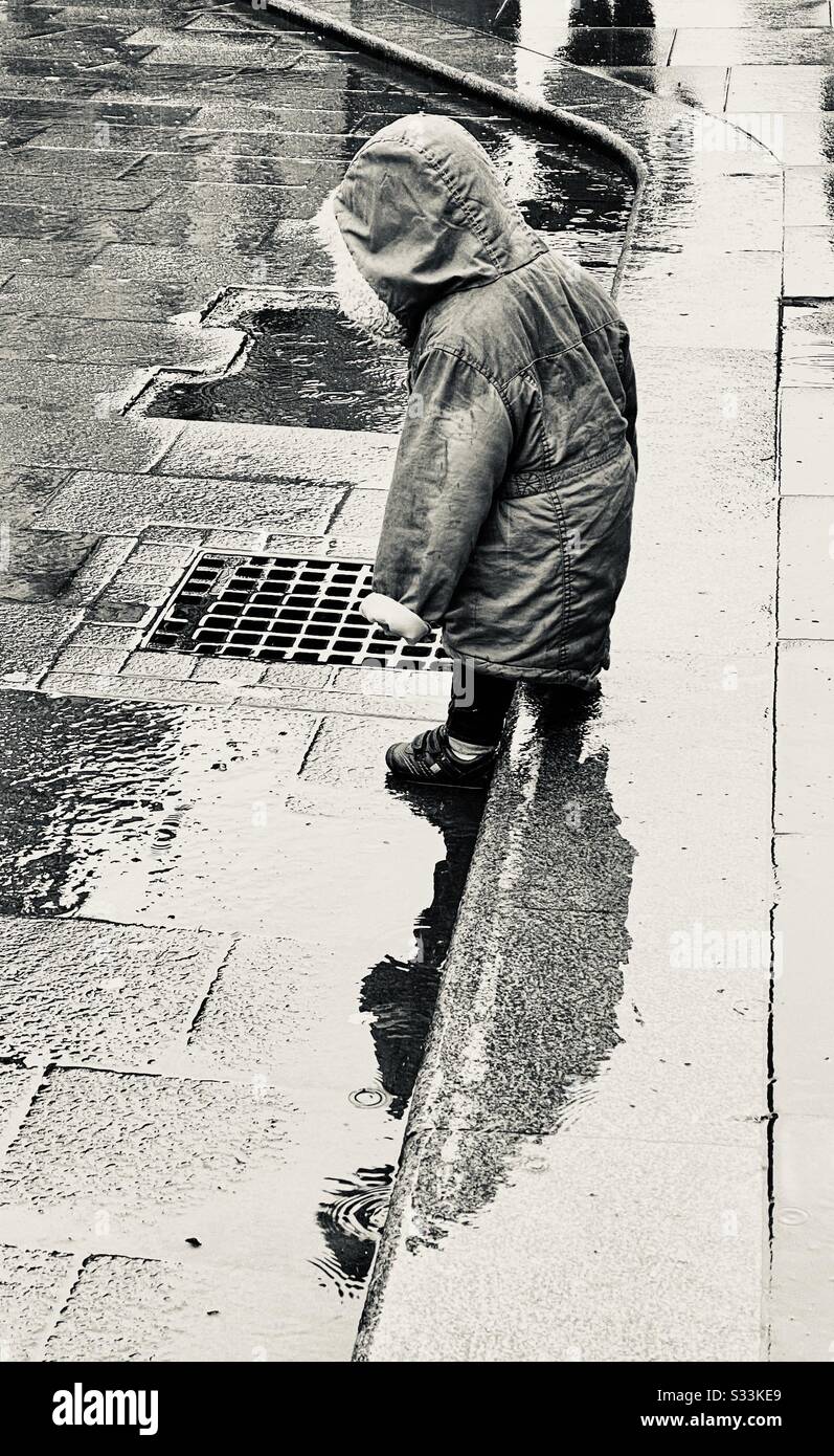 Niño en un charco en el centro de Hereford Foto de stock