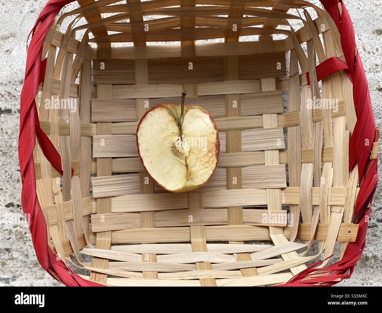 Mitad de manzana marchitada en una cesta de mimbre Foto de stock