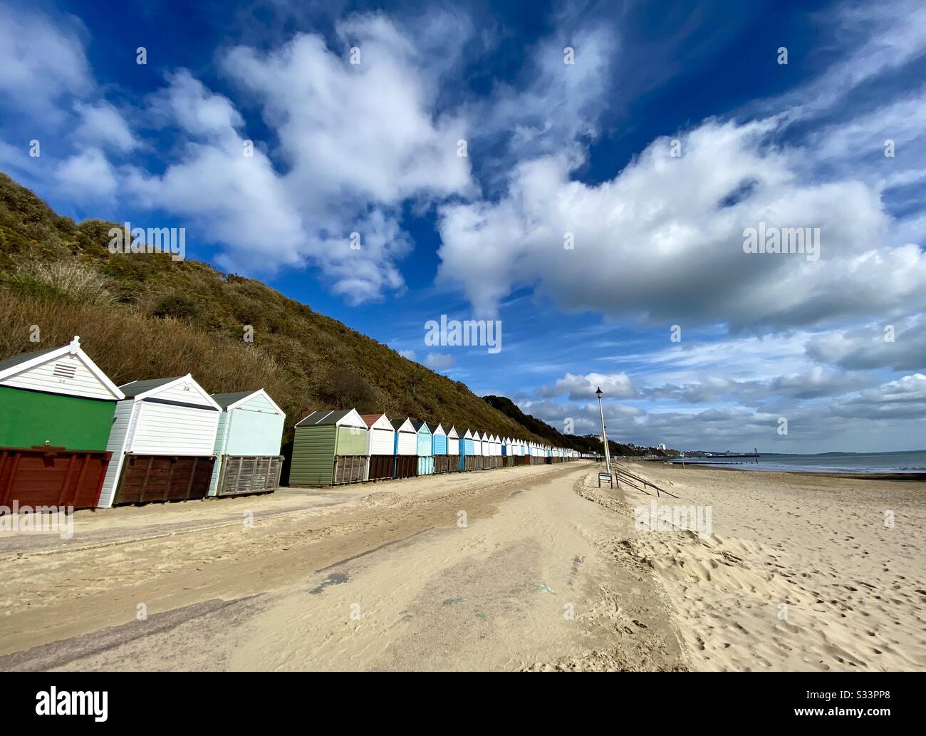 Una línea de cabañas de playa en el paseo de Bournemouth en invierno con un gran cielo, Reino Unido. Foto de stock