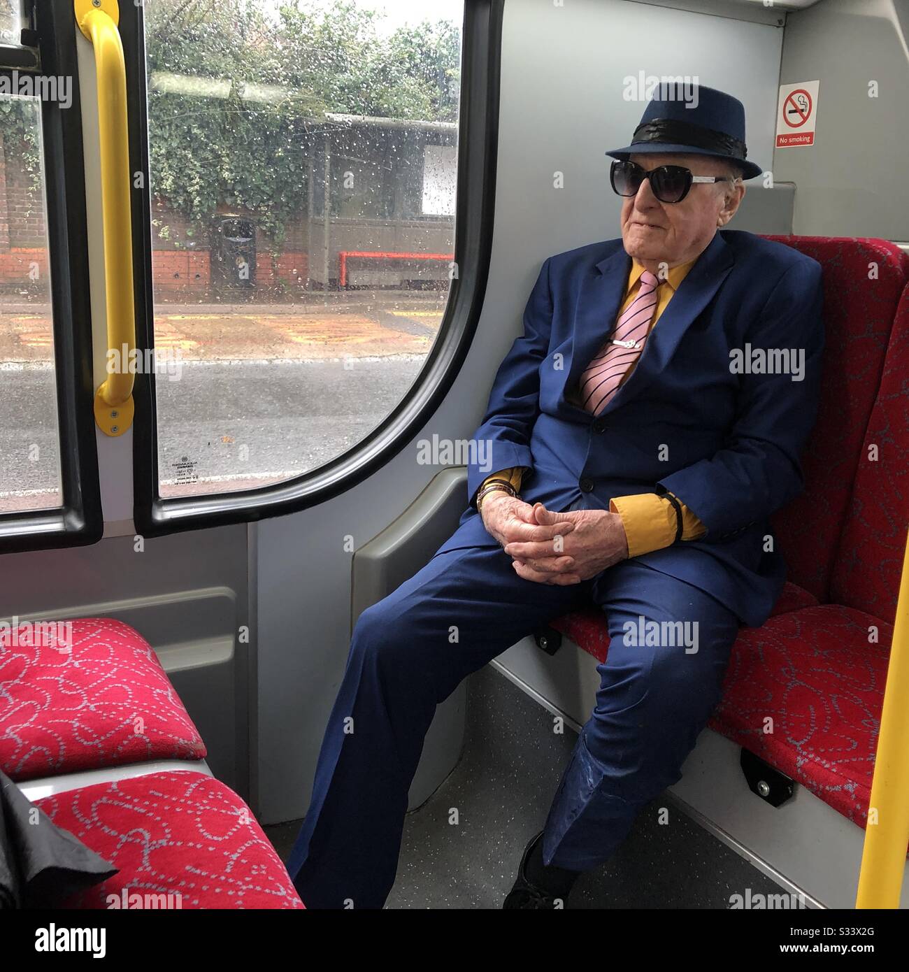 Un ciudadano mayor en traje sombrero y corbata en el autobús de Londres Foto de stock