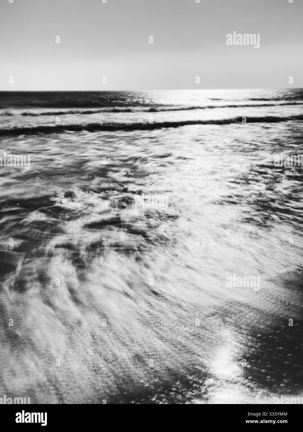 Una larga exposición de olas en blanco y negro en una playa de Florida, Estados Unidos. Foto de stock
