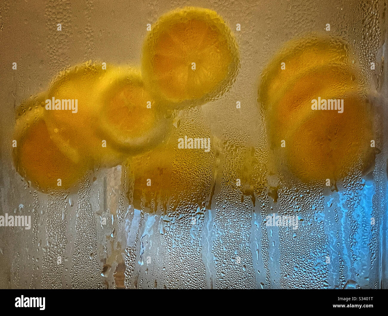 Rodajas de limón flotando en agua fría y helada Foto de stock