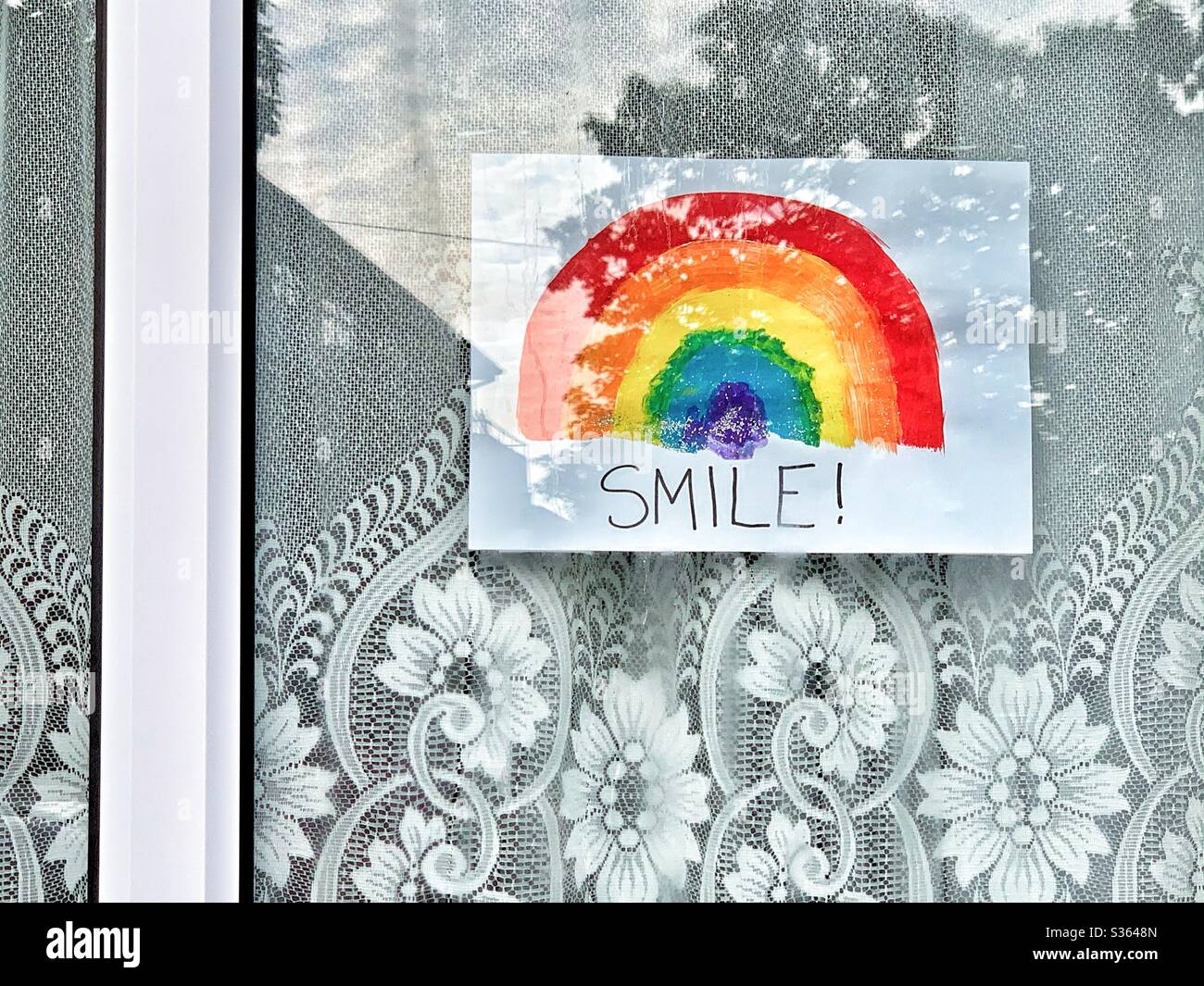 Mensaje arco iris en una ventana durante la pandemia del Coronavirus. Foto de stock