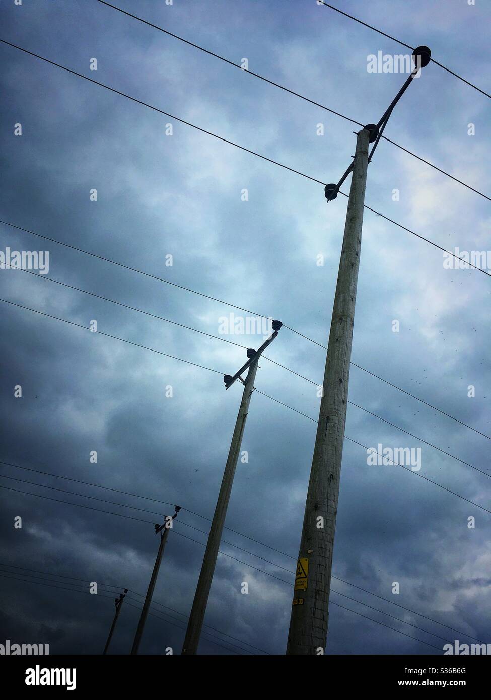 4 polos eléctricos en fila Fotografía de stock - Alamy