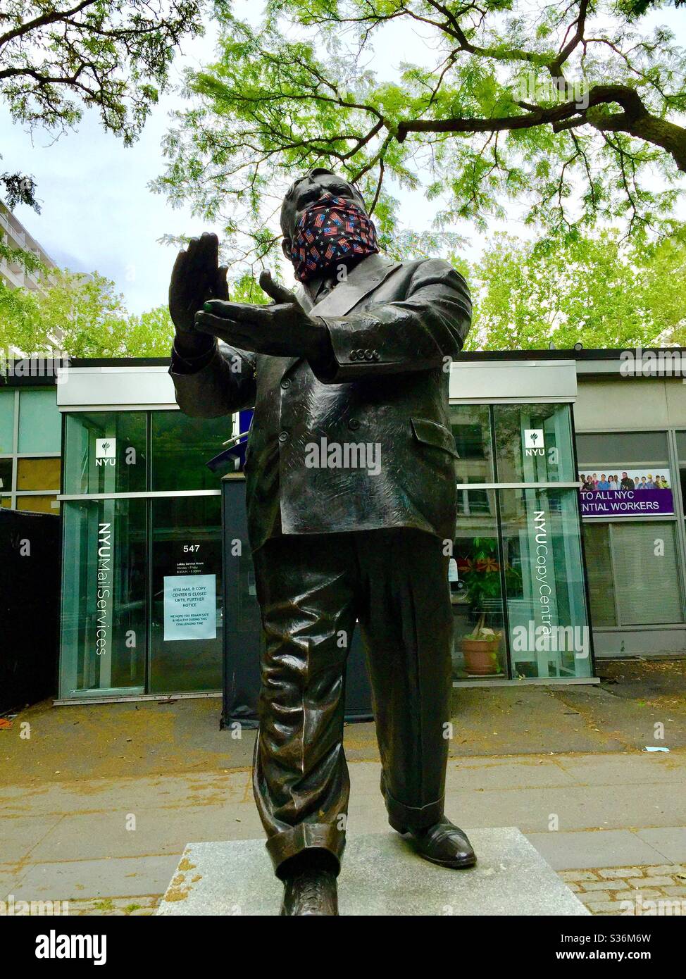 Estatua de Fiorello H LaGuardia con una máscara patriótica Coronavirus durante la pandemia en LaGuardia Place, Nueva York, EE.UU Foto de stock