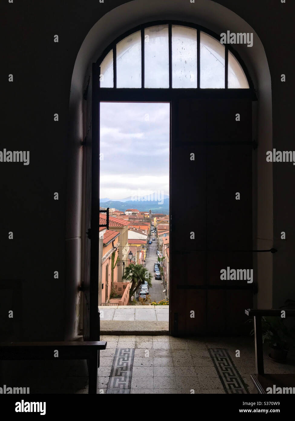 Una vista de una ciudad italiana en Cerdeña desde el interior de una iglesia en una colina. Foto de stock