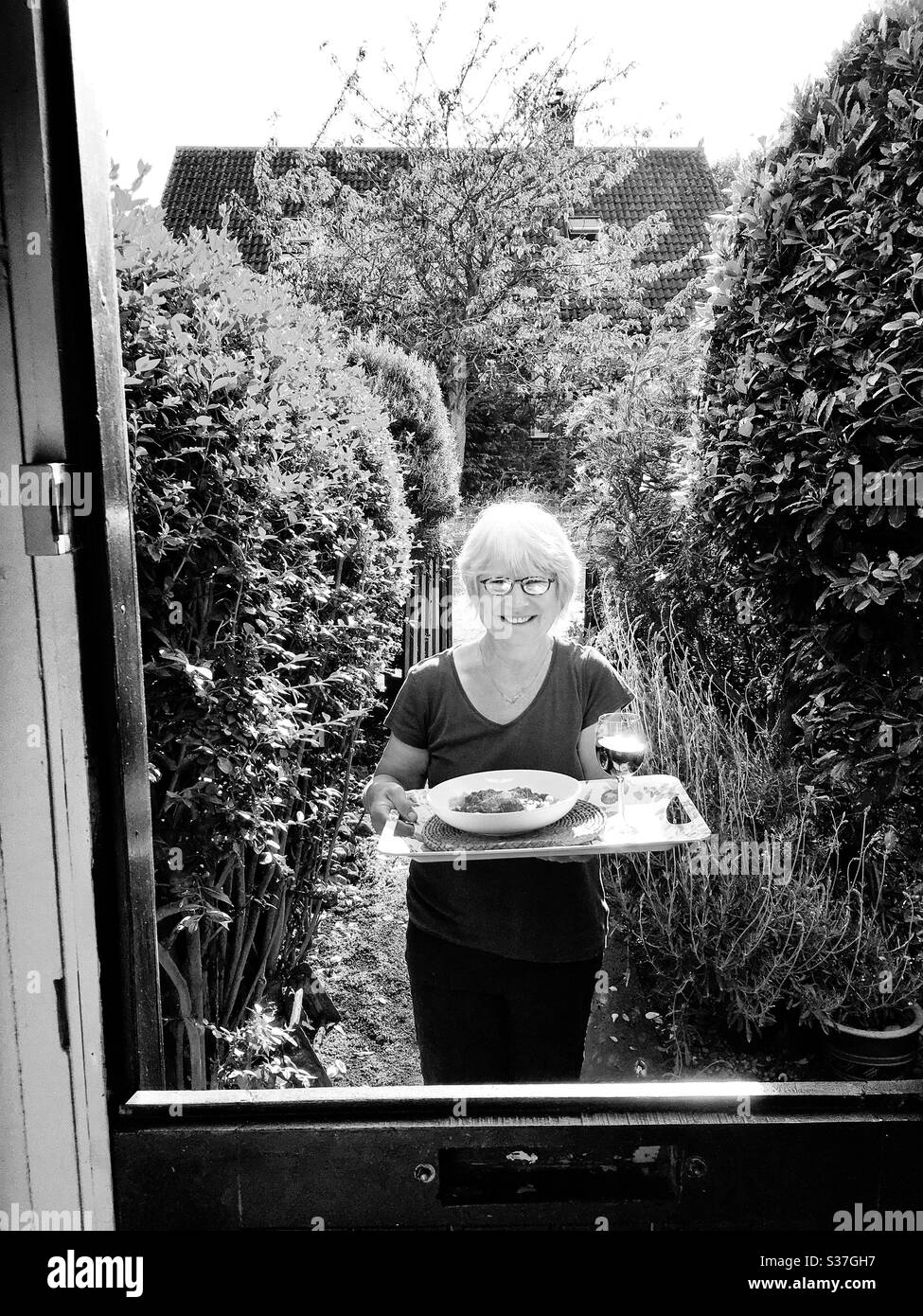 Vecino de al lado que trae una cena y vino cocidos a la puerta durante el cierre de Coronavirus 2020 Bawdsey Suffolk England Foto de stock