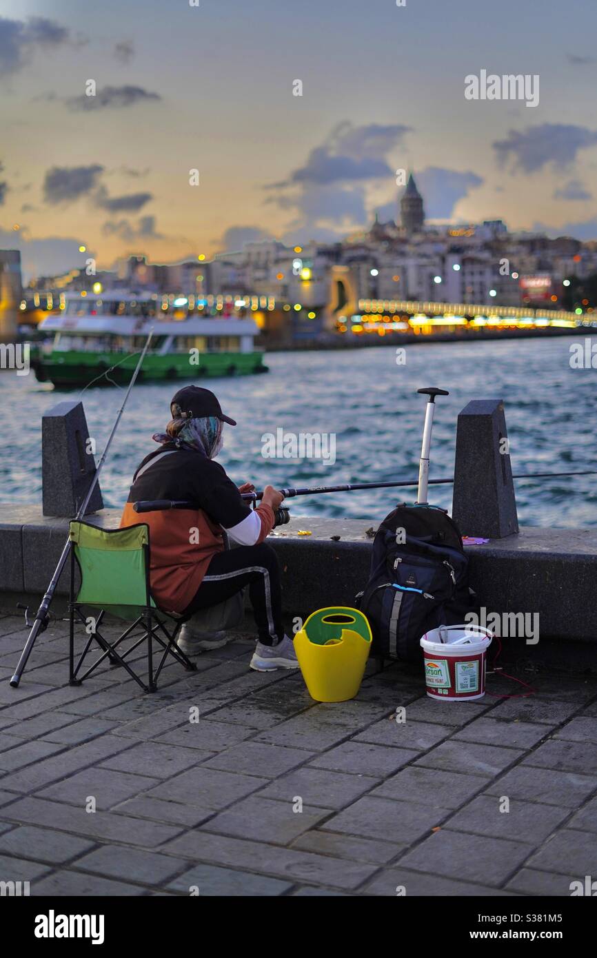 Una pescadora en el canal de Bosporus Estambul Foto de stock
