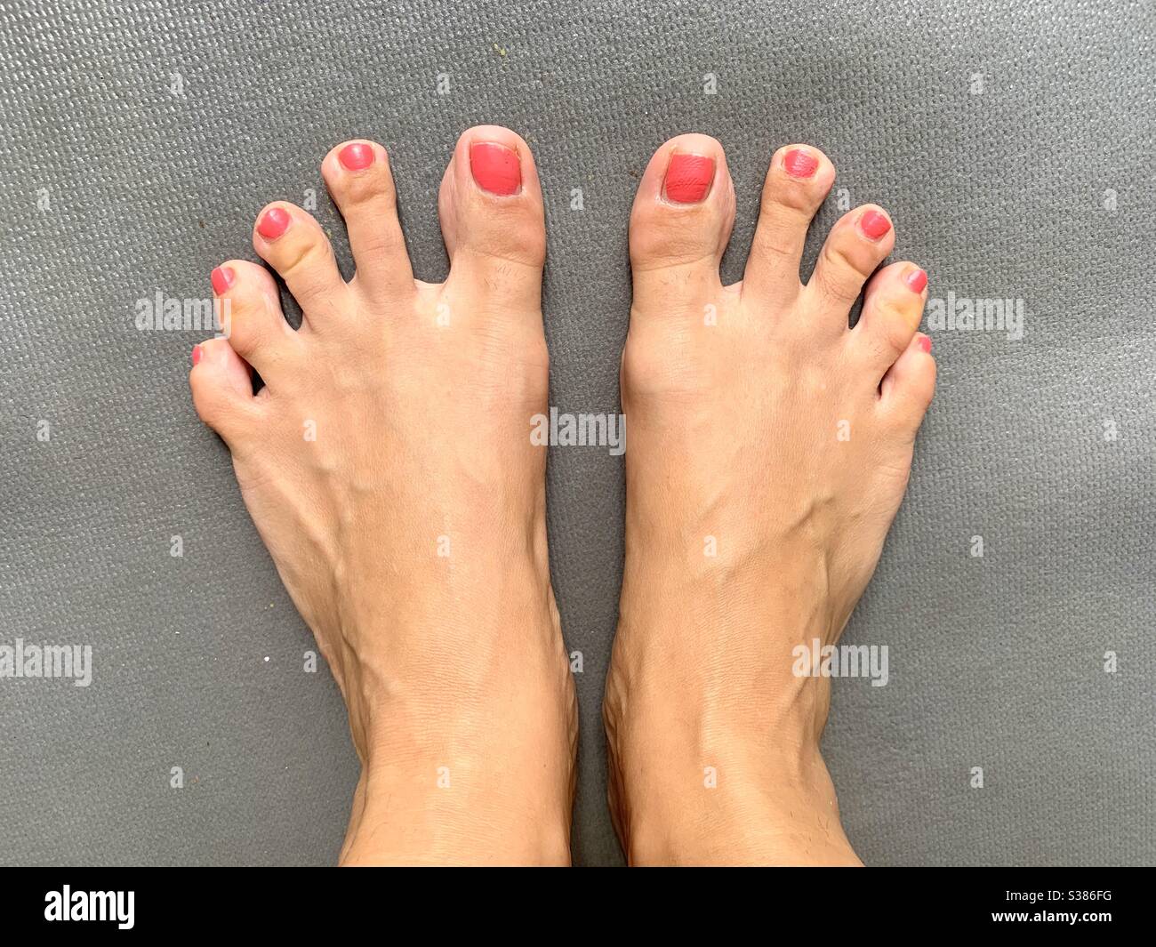 Dedos largos en los pies de la mujer con esmalte de uñas Foto de stock