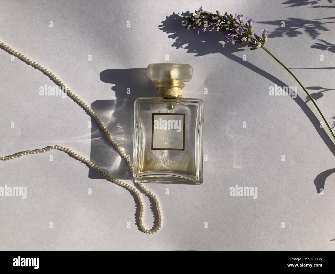botella de coco chanel con collar de perlas y flor de lavanda Fotografía de  stock - Alamy
