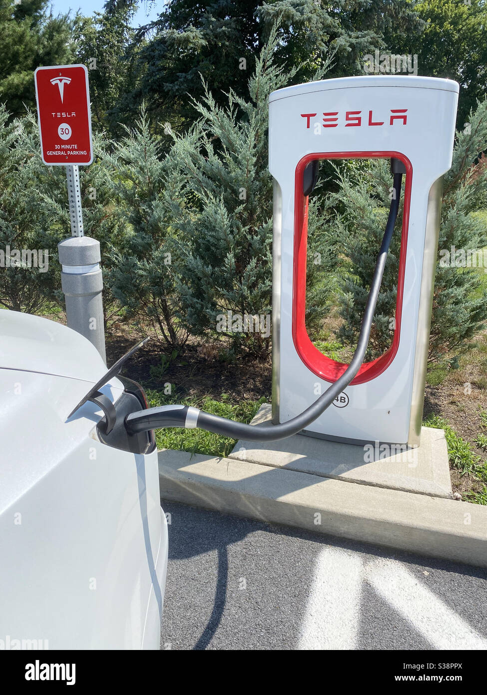 Carga de un Tesla Modelo 3 en un Supercharger en Nueva York, EE.UU. Foto de stock