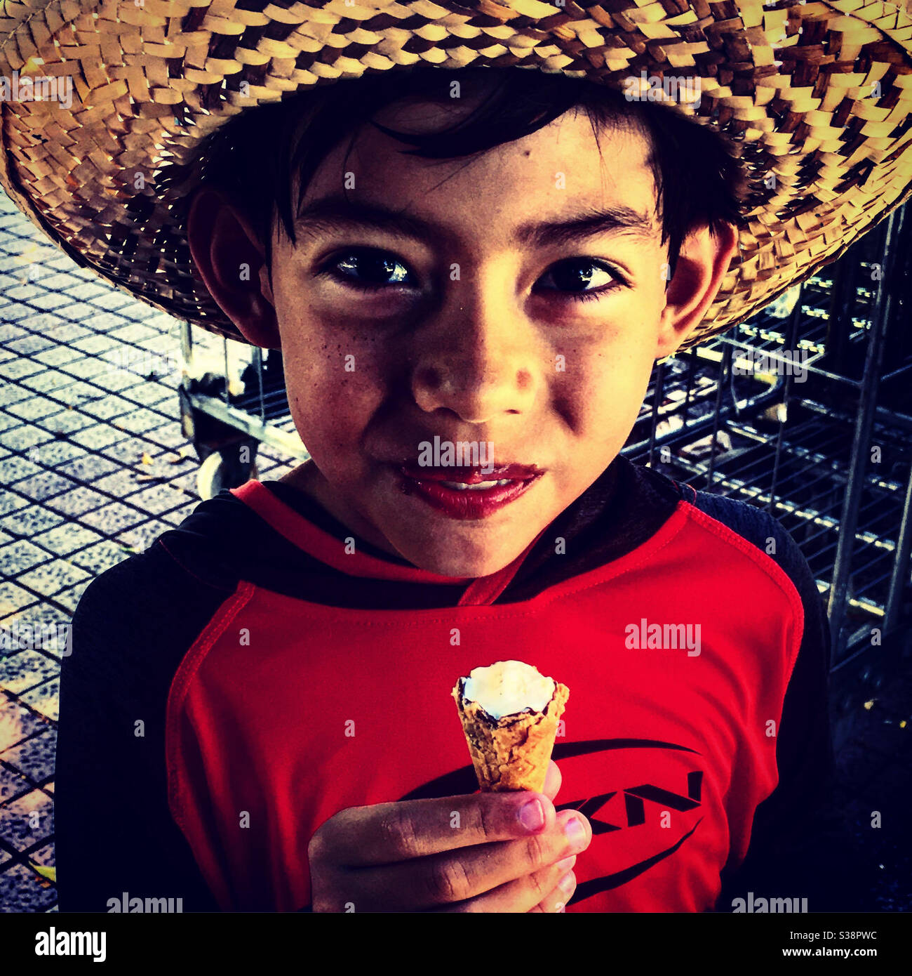 Niño pequeño disfrutando de un helado de cono por un tiempo caliente Foto de stock